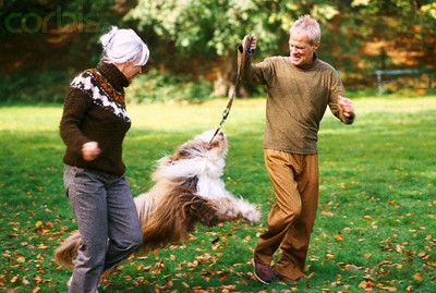 seniors walking dog in park